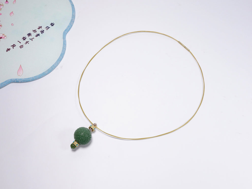 Collar con colgante de jade verde tallado y detalles dorados