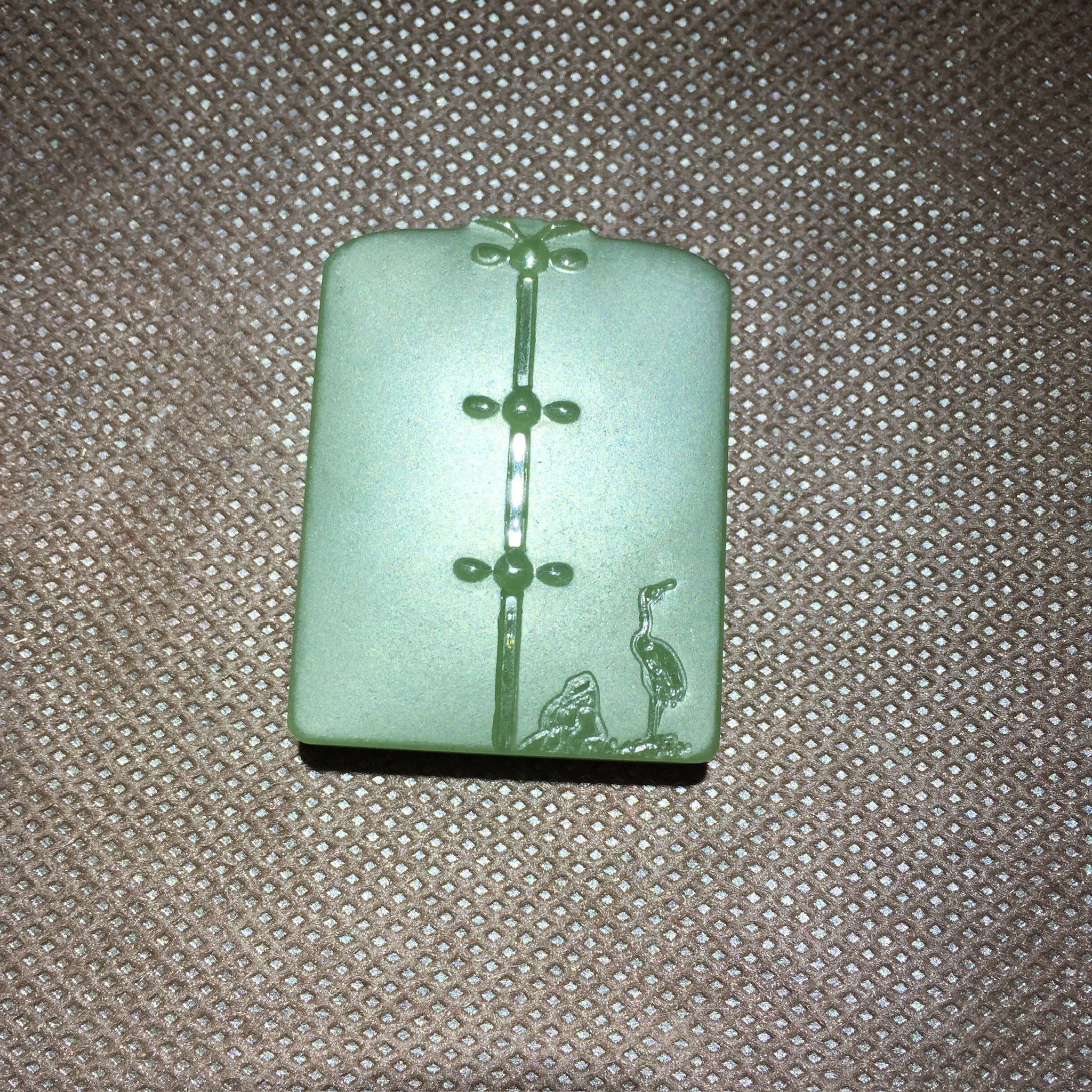 Colgante de placa tallada en jade verde con motivo simbólico