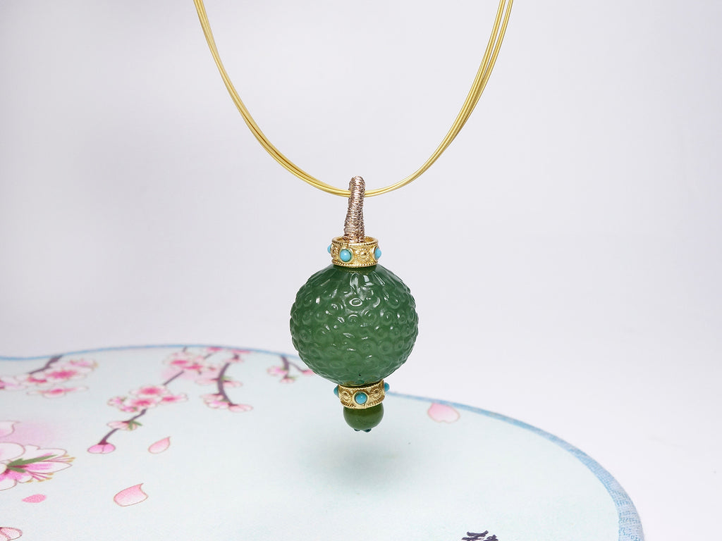 Collar con colgante de jade verde tallado y detalles dorados