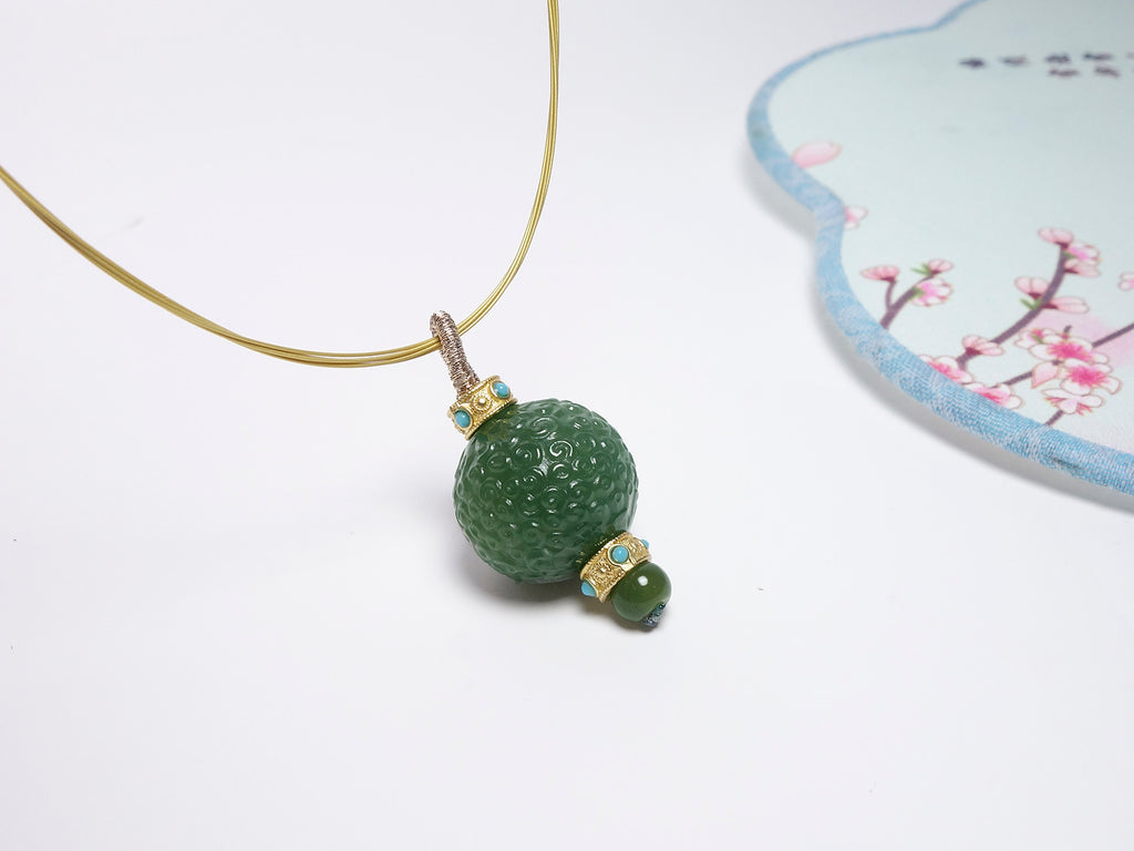 Collar con colgante de jade verde tallado y detalles dorados