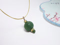Collar con colgante de jade verde tallado y detalles dorados