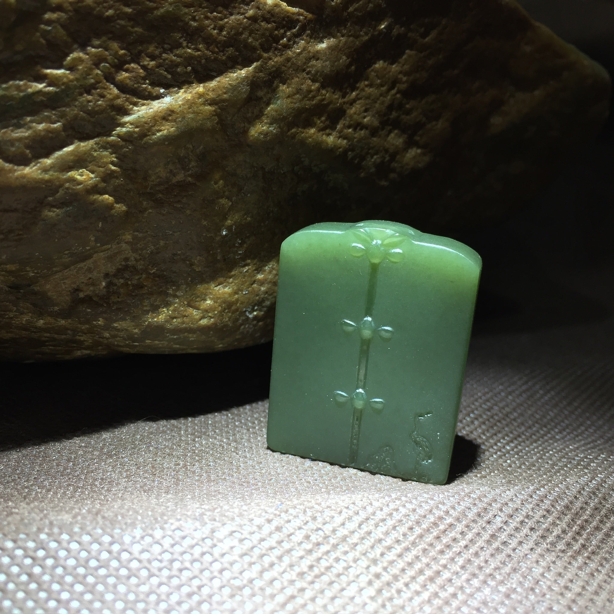 Colgante de placa tallada en jade verde con motivo simbólico
