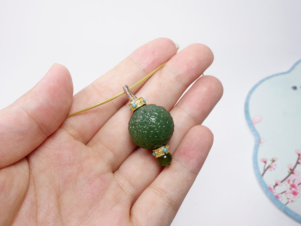 Collar con colgante de jade verde tallado y detalles dorados