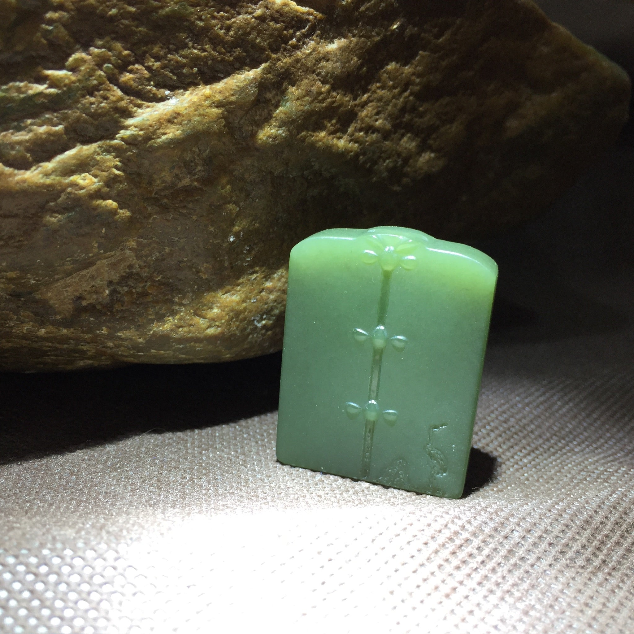 Colgante de placa tallada en jade verde con motivo simbólico