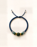 Azul Profundo pairs a steel-blue hand-braided silk cord with three green nephrite jade beads and small gold-plated bronze spacers.