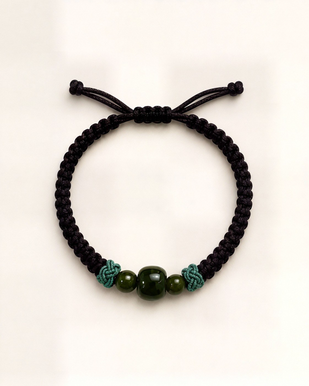 Bosque centres on three green nephrite jade beads framed by teal decorative knots.