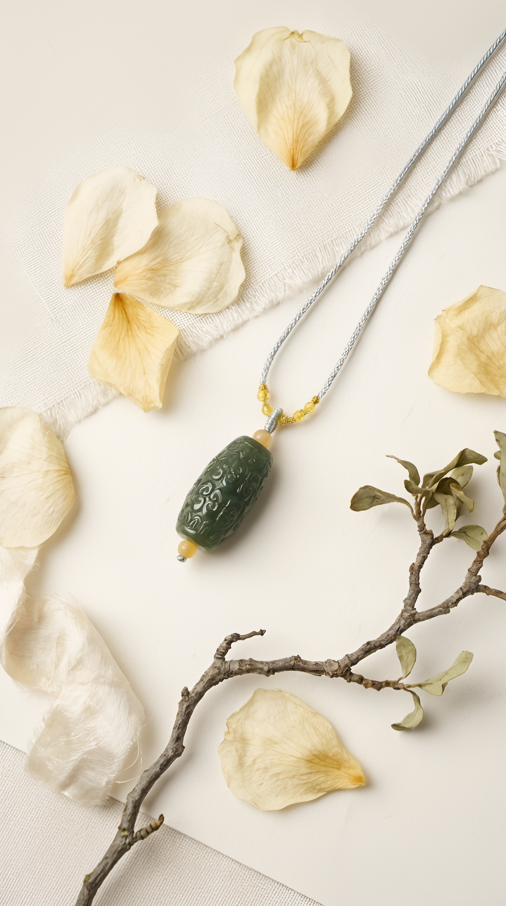 Nephrite jade barrel pendant necklace with gold chain on fabric