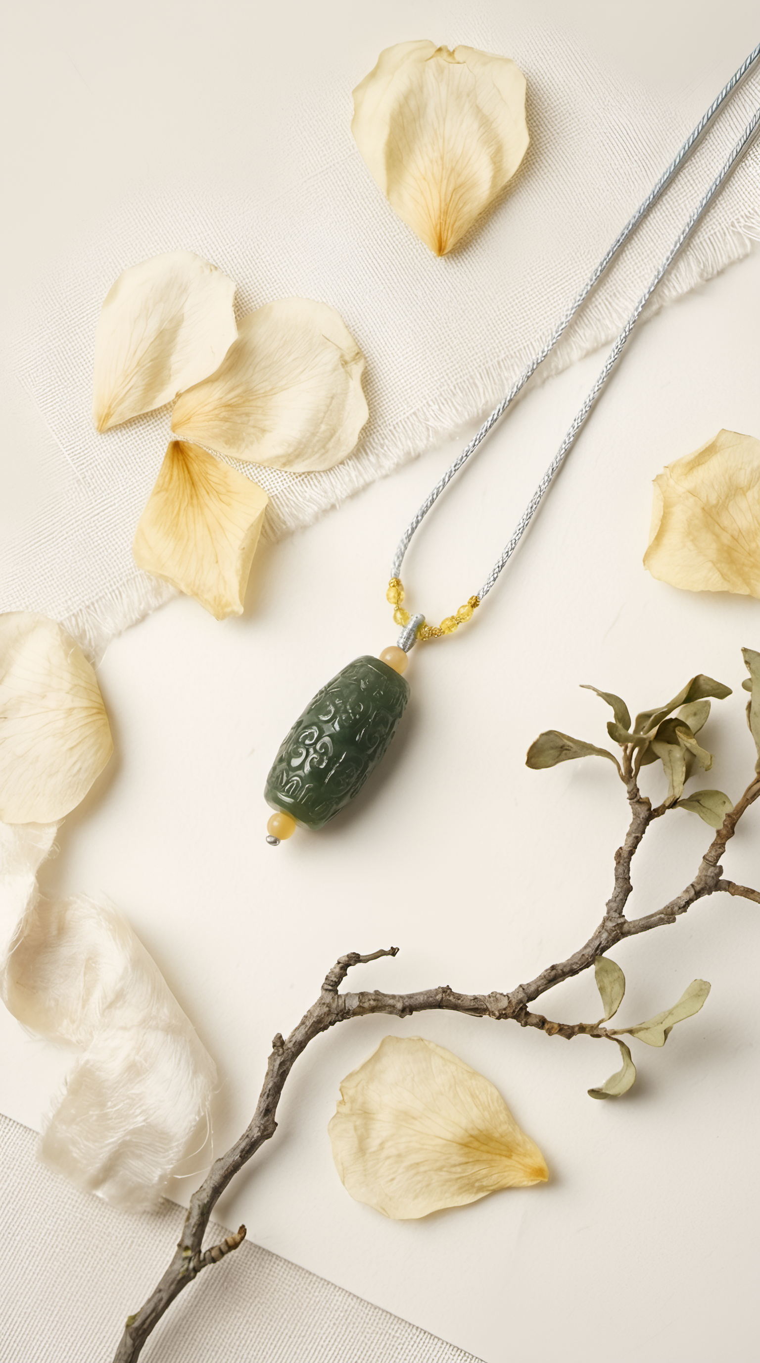 Nephrite jade barrel pendant necklace with gold chain on fabric