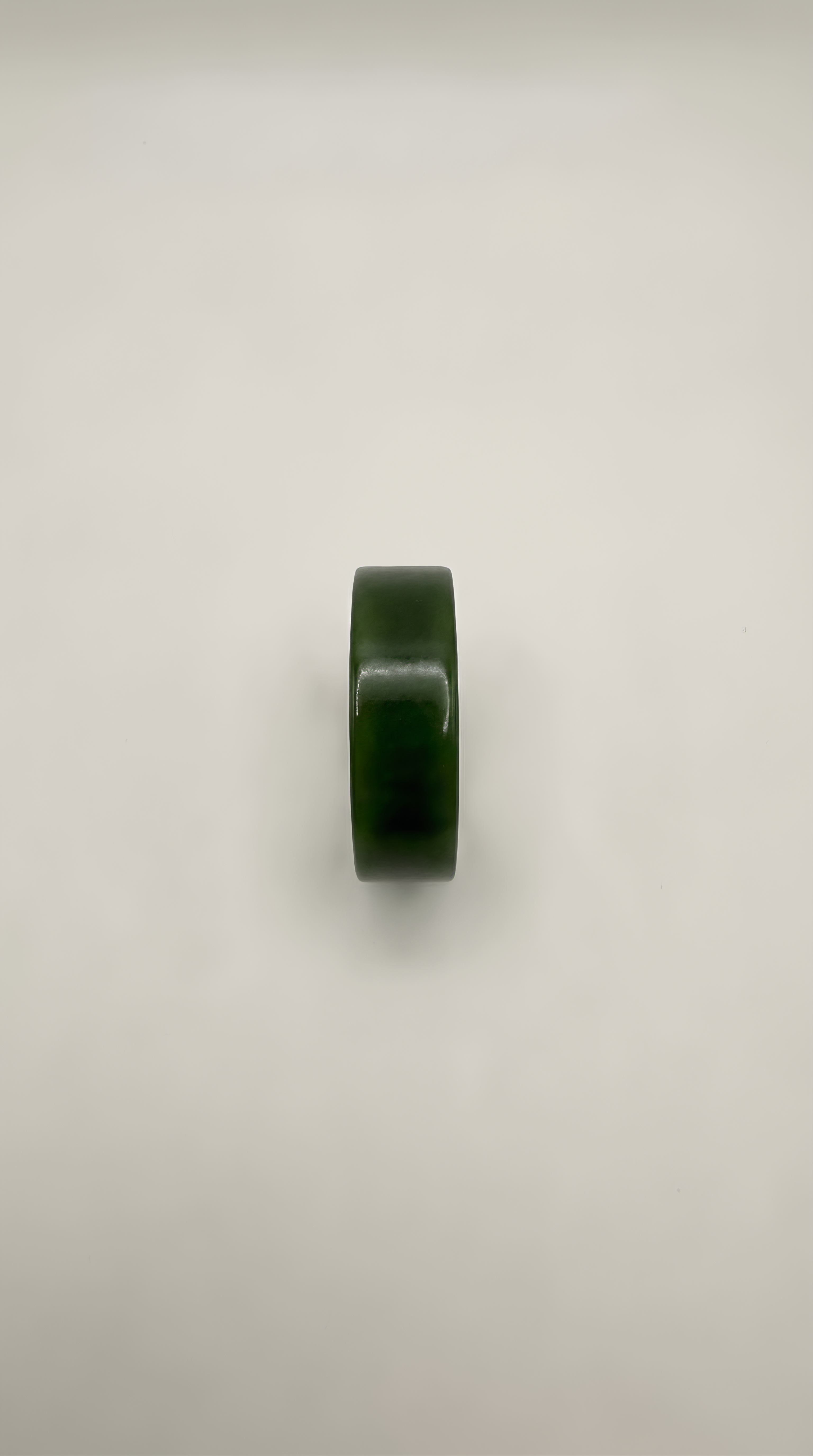 Green jade flat band ring detail showing natural stone colour