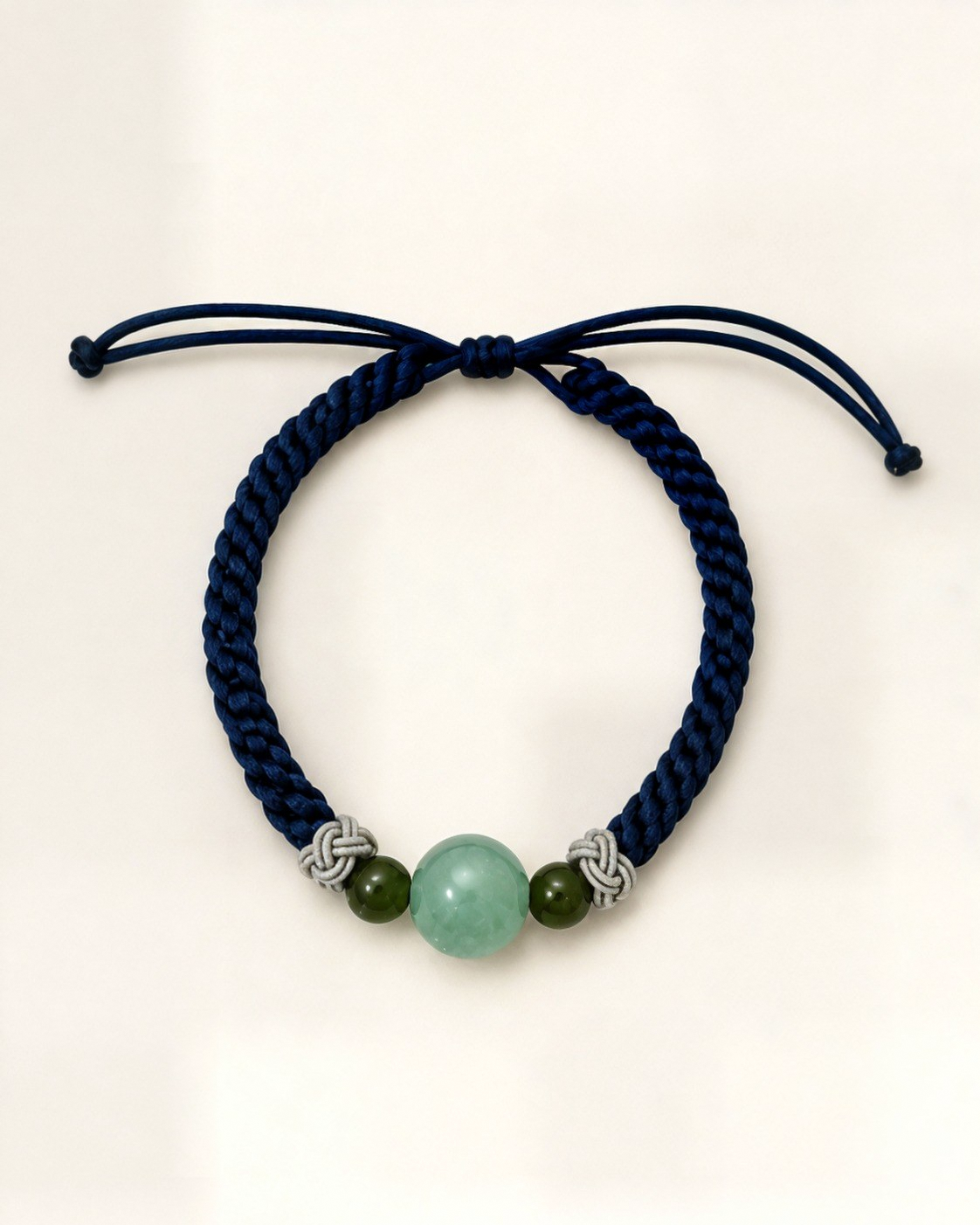 Horizonte combines a navy blue hand-braided silk cord with an aqua-green nephrite jade centre bead and two olive-green nephrite jade beads.