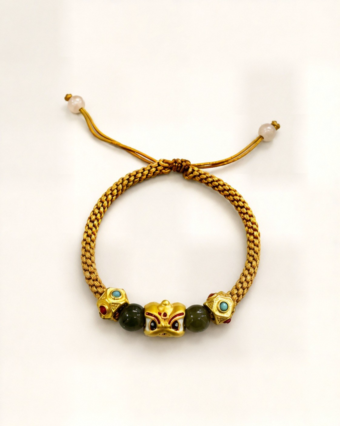 Luz de Oriente pairs a mustard hand-braided silk cord with a gold-plated bronze centre ornament featuring coloured details.