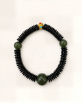 Órbita places three natural green nephrite jade beads among dark bodhi discs.