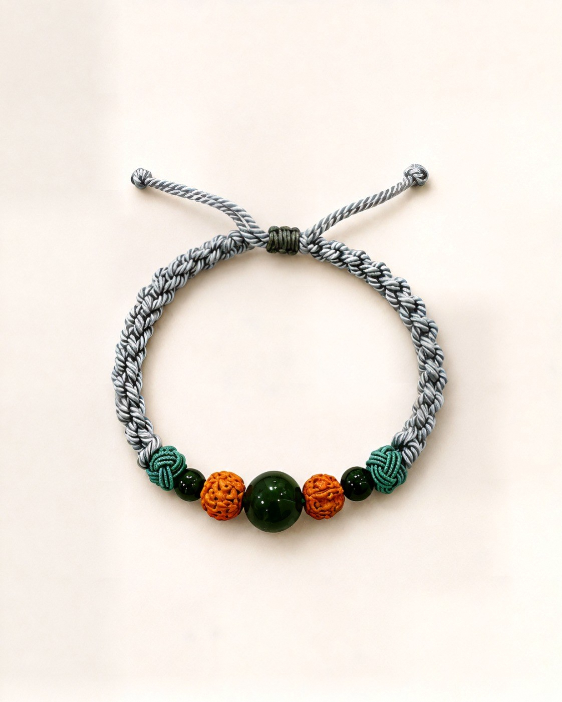 Tierra pairs a grey hand-braided silk cord with three green nephrite jade beads and two textured, carved bodhi beads.