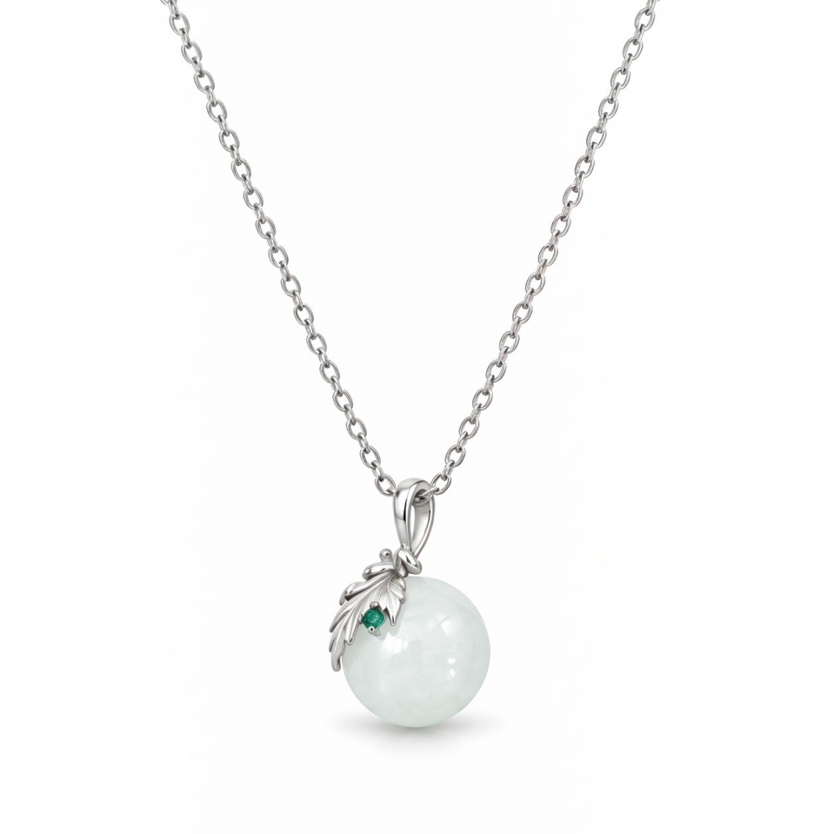 Close-up of the Flora white nephrite jade sphere with a sterling silver leaf and green cubic zirconia.