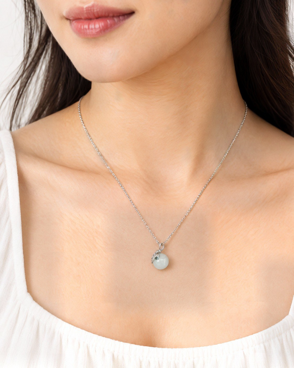 Flora necklace with a white nephrite jade sphere worn by a model.