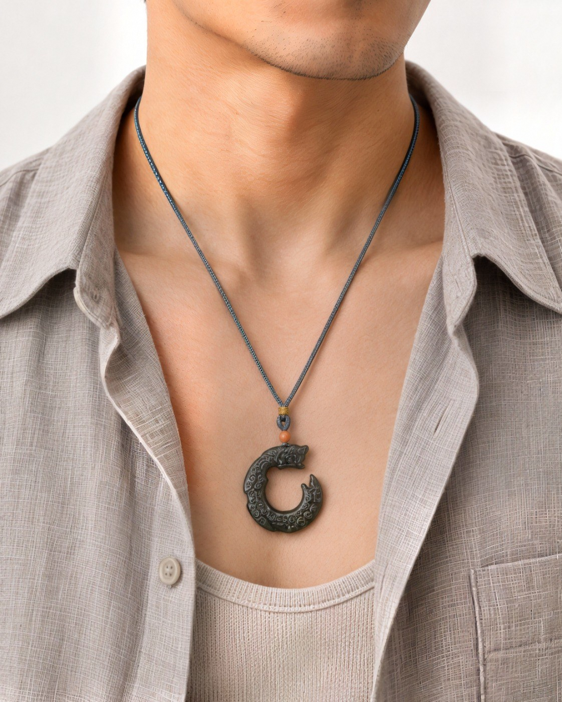 Guardián green nephrite jade Dragon pendant worn with a neutral outfit.