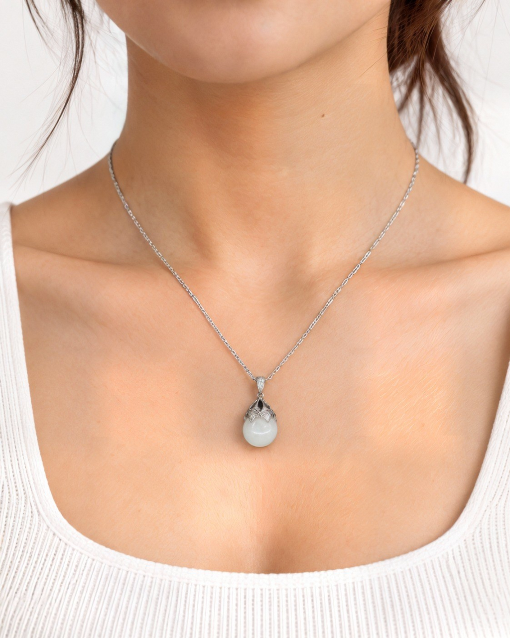 Luna white nephrite jade necklace worn at the collarbone.