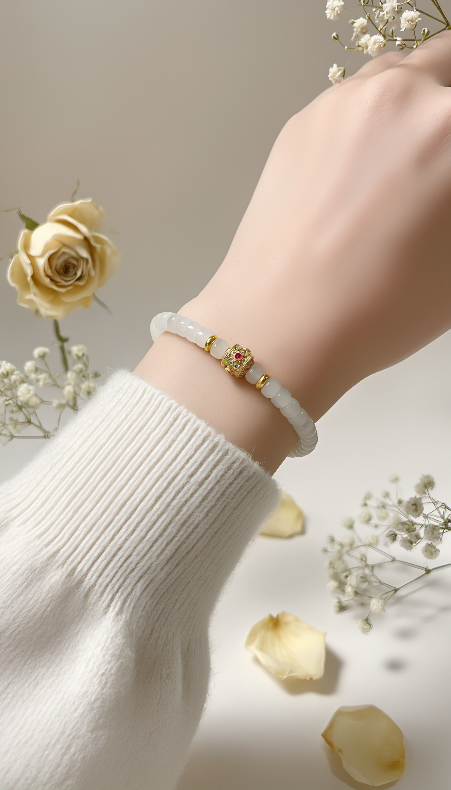 White jade bracelet with gold bead worn on wrist