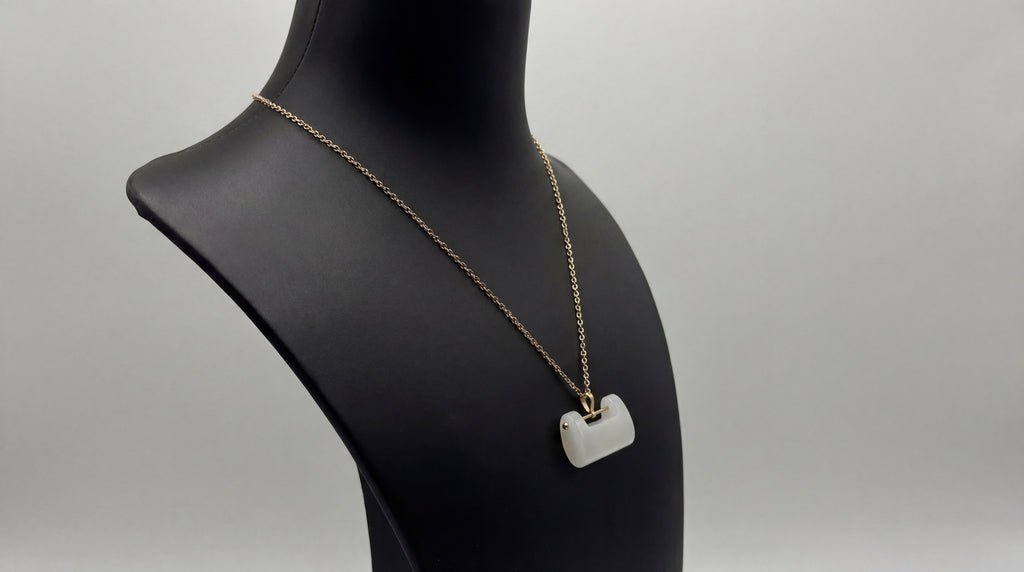 white padlock jade pendant sideview against a black mannequin